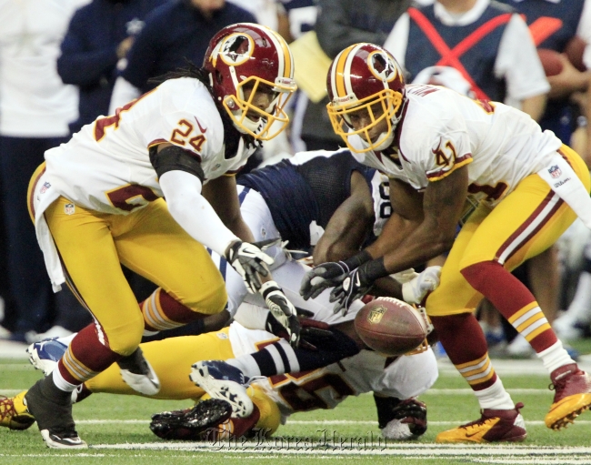 Washington Redskins strong safety DeJon Gomes (left) recovers a fumble by Dallas Cowboys wide receiver Dez Bryant (center), as Redskins teammate Madieu Williams (right) watches, during the second quarter at Texas Stadium in Arlington, Texas, Thursday .   MCT