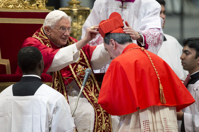Newly elected Cardinal Ruben Salazar Gomez of Colombia (right) receives the red three-cornered biretta hat from Pope Benedict XVI during a consistory inside the St. Peter’s Basilica at the Vatican on Saturday.   AP-Yonhap News