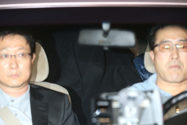 A trainee prosecutor accused of having sex with a suspect is seen in the backseat of a vehicle, covering his face with a cloth, leaving the Supreme Prosecutors’ Office in Seoul late Saturday after being interrogated by fellow prosecutors.   Yonhap News