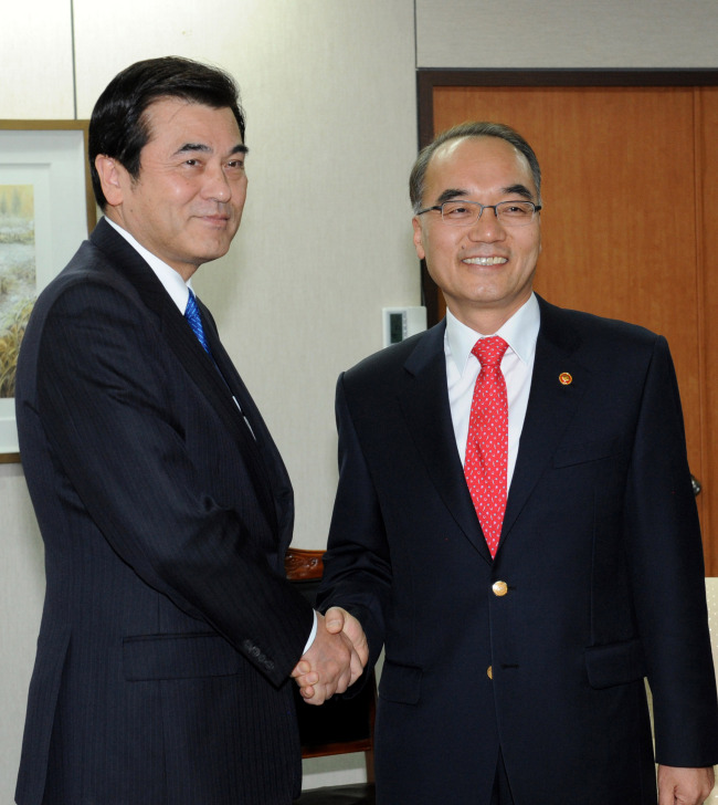 Korean Finance Minister Bahk Jae-wan (right) greets his Japanese counterpart Koriki Jojima at his office in Gwacheon, Gyeonggi Province, on Saturday.   Yonhap News