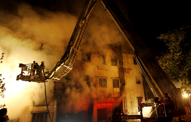 Bangladeshi firefighters battle a fire at a garment factory in the Savar neighborhood in Dhaka, Bangladesh, Saturday.   AP-Yonhap News