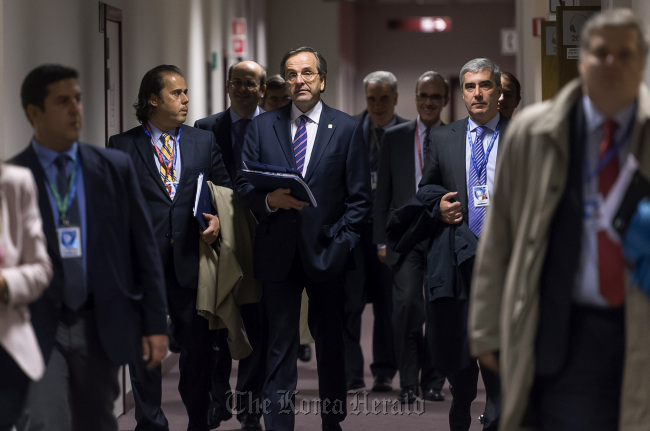 Antonis Samaras, Greece‘s prime minister (center) arrives to speak at a news conference following the European Union leaders summit meeting at the European Council headquarters in Brussels on Friday.   Bloomberg