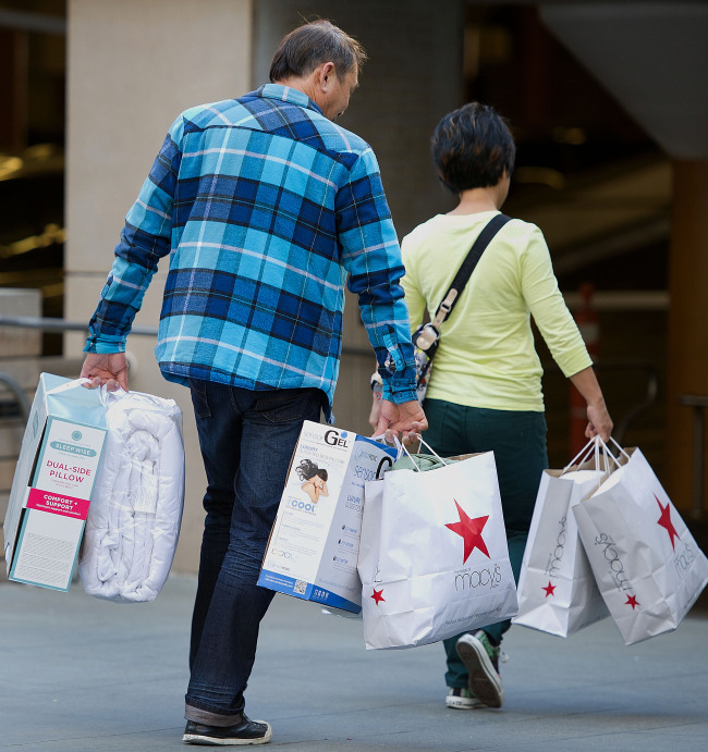 Customers carry Macy’s Inc. shopping bags in San Francisco on Friday.   Bloomberg