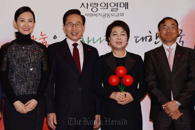 President Lee Myung-bak and first lady Kim Yoon-ok after receiving the “fruit of love” badge from marathoner Lee Bong-ju (right) and actress Chae Shi-ra (left), the honorary ambassadors of the Community Chest of Korea, at Cheong Wa Dae on Monday.   Chung Hee-cho/The Korea Herald