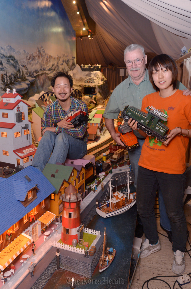 Gerry McElligott (center), designer of Christmas Display Artists and his team members, Kim Yoon-jun (left) and Park Hee-jung, pose for a photo at the train display at the Millennium Seoul Hilton.   Lee Sang-sub/The Korea Herald