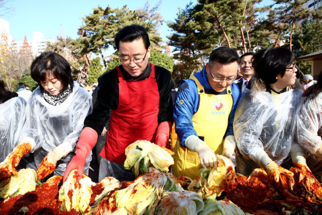최규원(좌두번째/금융인/경남은행 본부장),김맹곤(김해시장)
경남은행은 27일 김해시와 공동으로 ‘사랑의 김장 담그기 행사’를 가졌다. 김해시 내외동 주민센터에서 열린 사랑의 김장 담그기 행사는 최규원 경남은행 본부장과 김해지역봉사대 15명, 김맹곤 김해 시장과 김해시새마을부녀회 등 각계각층 봉사자 120여명이 참가했다.봉사자들은 미리 준비한 김치속과 절임 배추를 정성껏 버무려 2400포기의 김장김치를 담궜다.