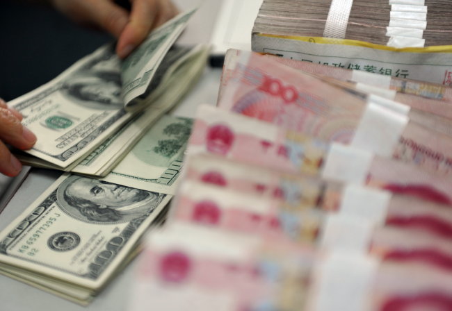 <YONHAP PHOTO-1799> (121112) -- QIONGHAI, Nov. 12, 2012 (Xinhua) -- A worker counts the U.S. dollars at a bank in Qionghai City, south China's Hainan Province, Nov. 12, 2012. The Chinese currency Renminbi, or the yuan, strengthened 92 basis points to 6.2920 against the U.S. dollar on Monday, according to the China Foreign Exchange Trading System. (Xinhua/Meng Zhongde) (ry)/2012-11-12 21:22:48/ <저작권자 ⓒ 1980-2012 ㈜연합뉴스. 무단 전재 재배포 금지.>
A worker counts U.S. dollars at a bank in Qionghai City, Hainan province, China.   Xinhua-Yonhap News