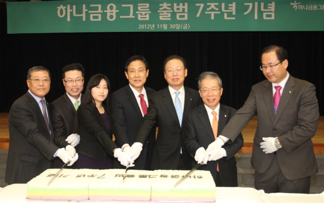 하나금융지주는 30일 서울 명동 외환은행 대강당에서 ‘하나금융지주 창립 7주년 기념식’을 개최했다. 김정태(오른쪽부터 네 번째) 하나금융그룹 회장, 윤용로(두 번째) 외환은행장 등 임직원들이 기념 떡 커팅을 하고 있다.  [사진제공=하나금융지주]