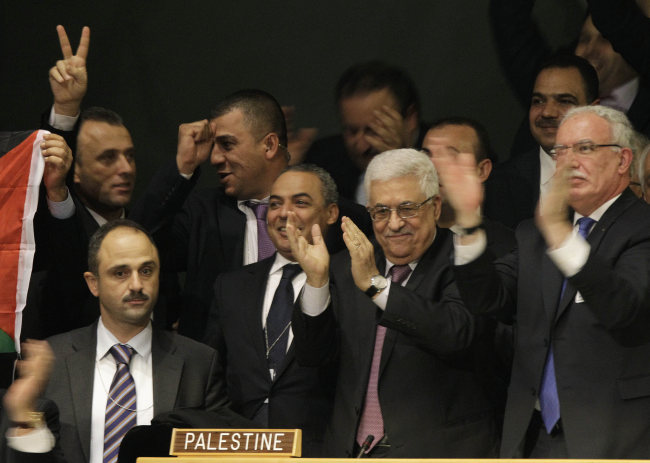 <YONHAP PHOTO-0605> Members of the Palestinian delegation react as they surround Palestinian President Mahmoud Abbas, center, who applauds during a meeting of the United Nations General Assembly after a vote on a resolution on the issue of upgrading the Palestinian Authority's status to non-member observer state passed in the United Nations in New York, Thursday, Nov. 29, 2012. (AP Photo/Kathy Willens)/2012-11-30 09:05:02/ <저작권자 ⓒ 1980-2012 ㈜연합뉴스. 무단 전재 재배포 금지.>
Members of the Palestinian delegation react as they surround Palestinian President Mahmoud Abbas (center), who applauds during a meeting of the United Nations General Assembly after a vote on a resolution on the issue of upgrading the Palestinian Authority’s status to non-member observer state passed in the United Nations in New York.   AP-Yonhap News