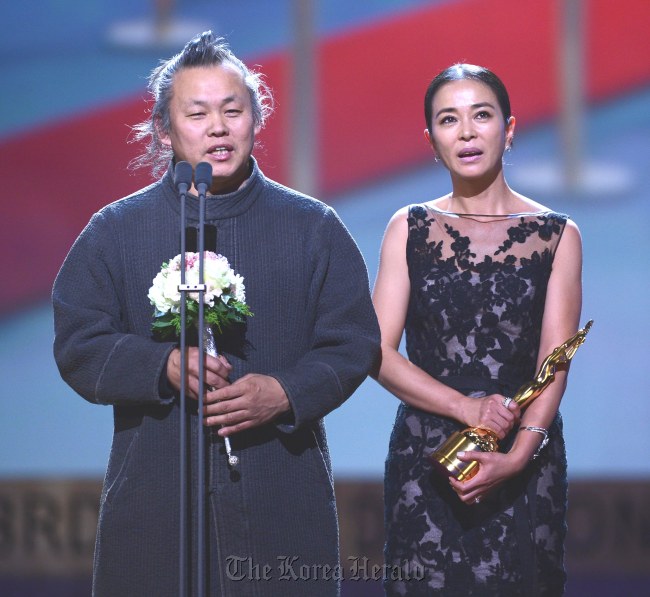 Director Kim Ki-duk (left) gives a speech, with actress Cho Min-soo on stage, after winning the top prize for their film “Pieta” at the 33rd Blue Dragon Film Awards on Friday.   Yonhap News