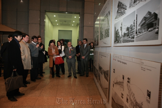 Portuguese Ambassador to Korea Antonio Quinteiro Nobre (fourth from right) listens to a tour guide during the exhibition opening of “Eduardo Souto de Moura Competitions: 1979-2010” at Yonsei University’s Atrium Hall on Monday.   Portuguese Embassy