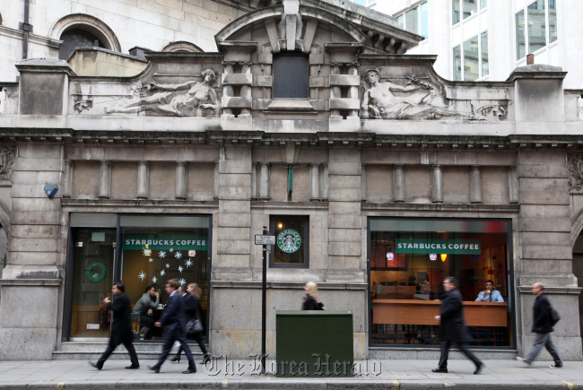 Pedestrians pass a Starbucks in London.   Bloomberg