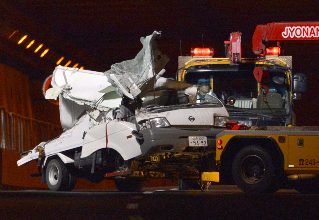 A tow truck hauls the wreckage of a truck, which was crushed in Sunday’s accident, out of the Sasago Tunnel on the Chuo Expressway in Koshu, Yamanashi Prefecture, Japan, Monday.   AP-Yonhap News
