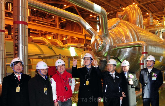 Knowledge Economy Minister Hong Suk-woo (center) looks around Shin-Gori nuclear power plant after attending a ceremony for the structures’ completion in Busan on Tuesday.   Park Hae-mook/The Korea Herald