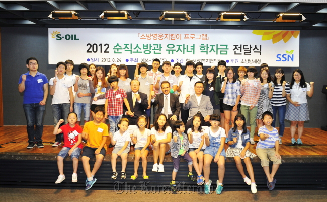 S-Oil CEO Nasser Al-Mahasher (third from left, second row) poses with children of fallen firefighters in a ceremony to award scholarships, held at the company’s head office in Mapo, Seoul, on Aug. 28.   S-Oil