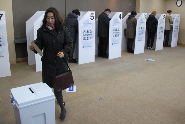 Koreans cast ballots at the polling station inside the Korean Embassy in Beijing on Wednesday, on the first day of absentee voting for overseas Koreans for the Dec. 19 presidential election.