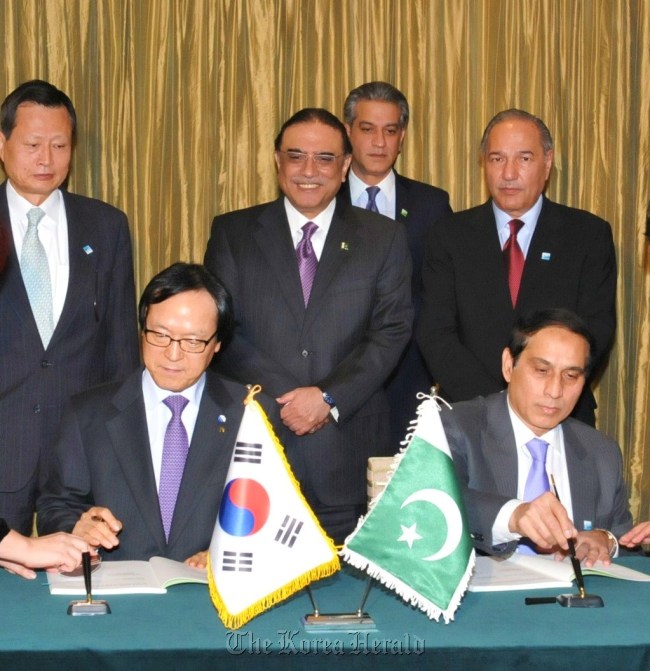 Export-Import Bank of Korea chief executive Kim Yong-hwan (left) signs an agreement in Seoul on Wednesday to offer $78 million in long-term, low-interest loans to Pakistan to support its tunnel
construction project. Pakistani President Asif Ali Zardari (middle row, center) looks on.   Eximbank