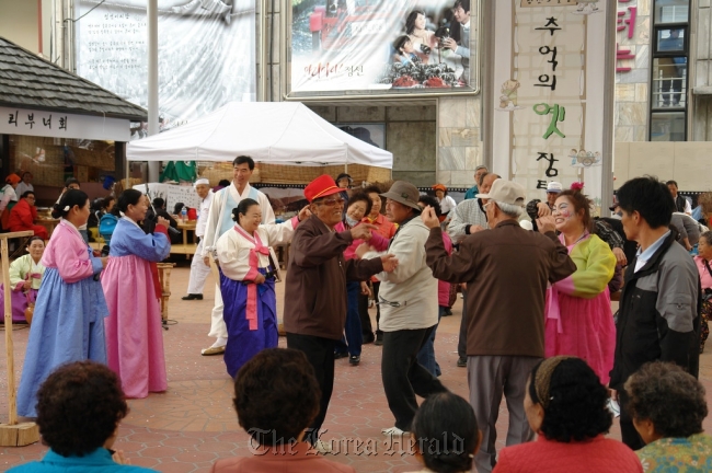 People sing and dance to Arirang at a village fair.   Cultural Heritage Administration