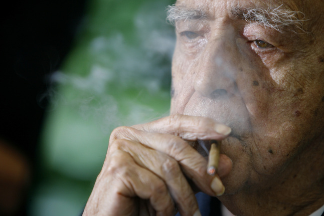 Brazil’s star architect Oscar Niemeyer smokes during his 100th birthday celebration in Rio de Janeiro, Brazil.   AP-Yonhap News
