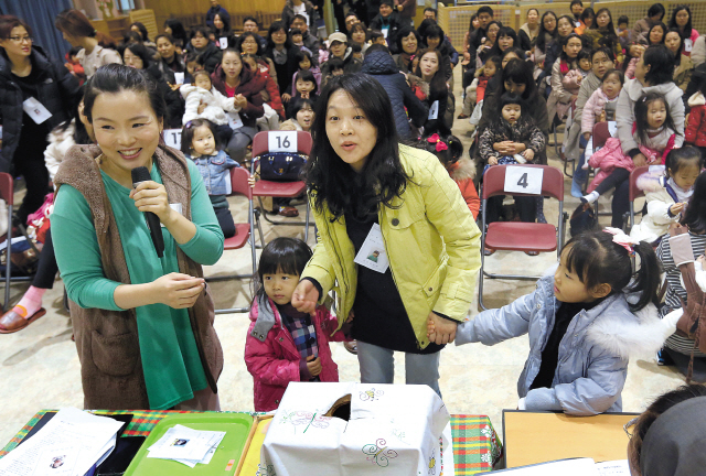 A woman rejoices after picking a winning number in a lottery held at a kindergarten in Yeongdeungpo, Seoul, Wednesday, to determine who among the applicants will be admitted next year. Yonhap News
