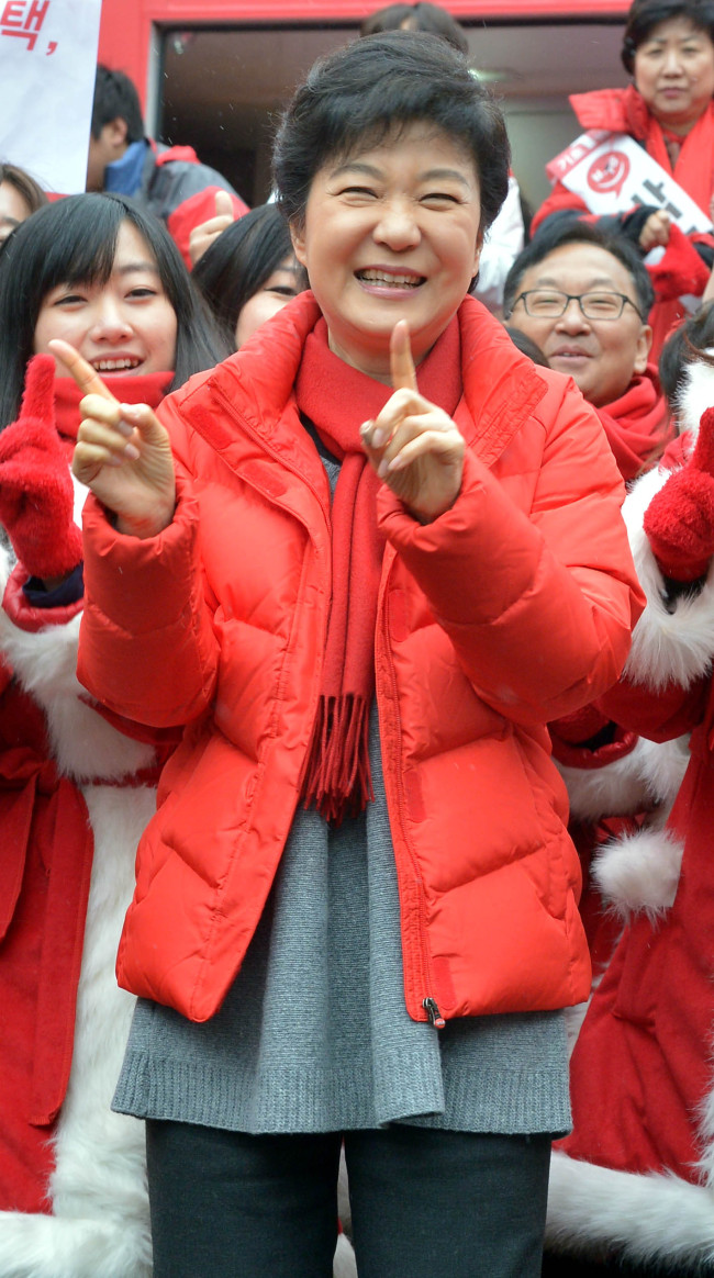 Saenuri Party candidate Park Geun-hye dances with campaign supporters at a market in southern Seoul on Friday.   (Park Hyun-koo/The Korea Herald)