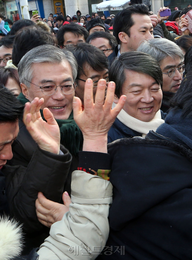 문재인 민주통합당 대선 후보와 안철수 전 무소속 후보가 9일 오후 경기도 군포시 산본역에서 만나 인파 속을 걸으며 유권자들에게 인사하고 있다.<br />정희조 기자/checho@heraldcorp.com 121209