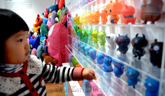 A girl looks at the toys on display at the “My Friend, My Hero” art-toy Collection at the Lotte Department Store in Cheongnyangni.    Park Hyun-koo/The Korea Herald