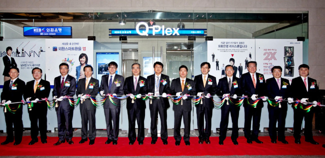 Officials of SK Telecom and Korea Exchange Bank cut the tape to open the Q’Plex Seoul Square branch in central Seoul on Tuesday.   SKT