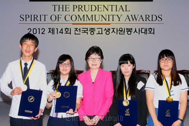 Prudential Life Insurance Co. of Korea head Sohn Byoung-ok (center) poses with the winners of the company’s 14th annual student volunteer community service competition in Seoul.   Prudential Life Insurance