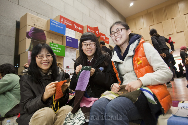 Participants in Save the Children’s knitting event work their needles.   Save the Children
