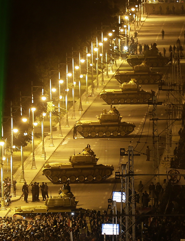 Egyptian Army tanks deploy outside the presidential palace as Egyptian protesters gather during a demonstration against President Mohammed Morsi in Cairo on Tuesday.   AP-Yonhap News