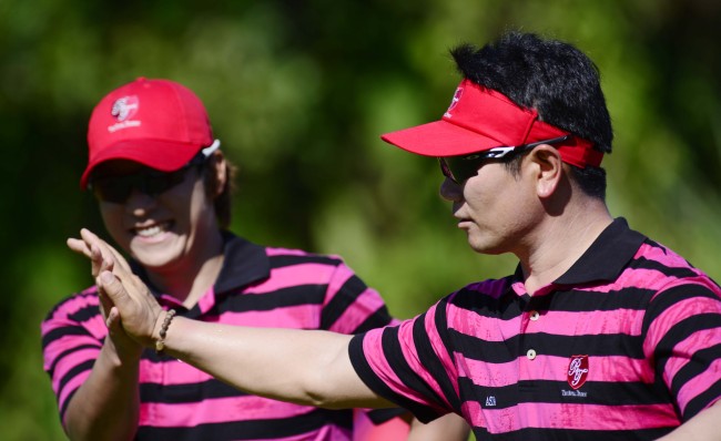 Yang Yong-eun (right) gives Kim Kyung-tae a high five after Kim drives in their ball on to the green of the par-five hole two for a birdie in one of the standout plays of the first day of the Royal Trophy at the Empire Hotel and Country Club in Brunei,Friday.
Park Hae-mook / The Korea Herald