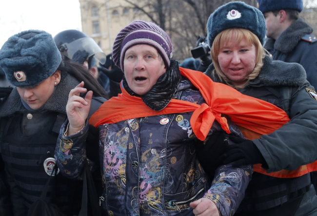 Police officers detain an opposition supporter during an unauthorized rally in Lubyanka Square in Moscow on Saturday.   AP-Yonhap News