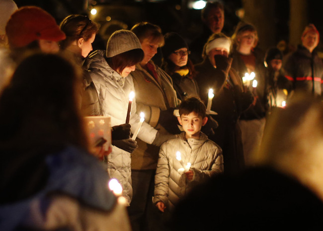 Mourners gather for a candlelight vigil at Ram's Pasture to remember shooting victims, Saturday. (AP-Yonhap News)