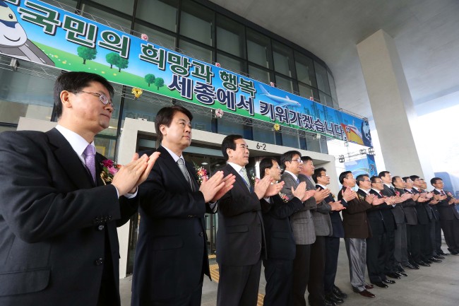 Land Ministry officials applaud during a ceremony to move into the new government office in Sejong City, South Chungcheong Province, on Monday.   Yonhap News