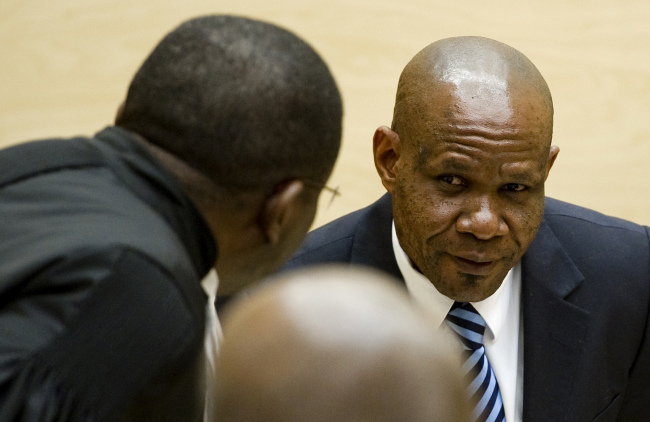 Former leader of the National Integrationist Front Mathieu Ngudjolo (right) listens to his lawyer prior to his verdict at the International Criminal Court in The Hague, Netherlands, Tuesday.   AP-Yonhap News