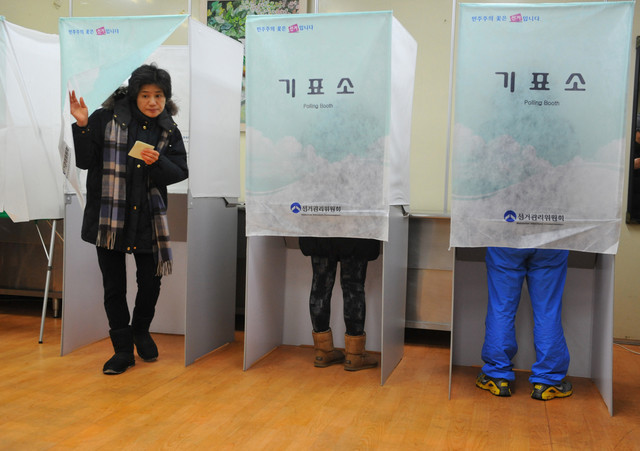 A South Korean woman leaves a polling booth to cast her vote in the country's presidential elections in Seoul, South Korea. (AFP)