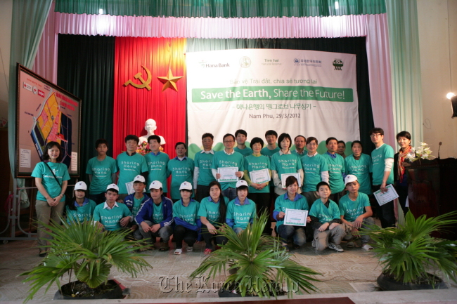 Hana Bank employees pose with local residents in Nam Phu, Vietnam, during an event for planting trees under its commitment to fulfilling a corporate social role in March 2012.   Hana Financial Group
Hana Bank employees pose with local residents in Nam Phu, Vietnam, during an event for planting trees under its commitment to fulfilling a corporate social role in March 2012.   Hana Financial Group