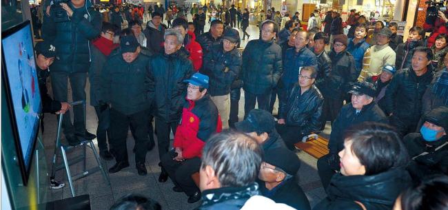 Citizens watch the announcement of the results of exit polls at Seoul Station on Wednesday. (Chung Hee-cho/The Korea Herald)