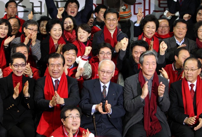 Members of Park Geun-hye's campaign and Saenuri Party officials clap as vote count shows Park's larger-than-expected win over Moon Jae-in of the Democratic United Party. (Park Hyun-koo/The Korea Herald)