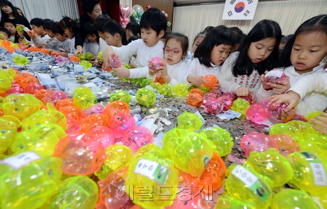 21일 오전 서울 광진구가 구청 대강당에서 구립어린이집 원아들이 고사리 손으로 모은 '사랑의 저금통 나누기' 행사를 개최하고 있다. 올해로 6번째를 맞는 이 행사는 관내 어린이집 22개소, 민간어린이집 58개소의 어린이들이 지난 5월부터 돼지저금통에 동전을 모아 어려운 이웃에게 전달함으로써 아껴쓰고 저축하는 습관과 기부 문화를 체험할 수 있도록 마련되었다./안훈기자 rosedal@ 2012.12.21
고사리 손들이 10원, 100원씩 모은 ‘정성’. 이 정성은 배고픈 돼지를 배부르게 했다. 지난 5월부터 서울 광진구 소재 구립 및 민간어린이집 원아들이 한 푼 두 푼 돼지저금통에 동전을 모았다. 어렸을 때부터 배운 나눔과 기부의 습관은 어른이 됐을 때도 이어진다. 21일 오전 서울 광진구청 대강당에서 아이들이 돼지저금통과 함께 세상에서 가장 아름다운 사진을 찍었다.  안훈 기자/rosedal@heraldcorp.com