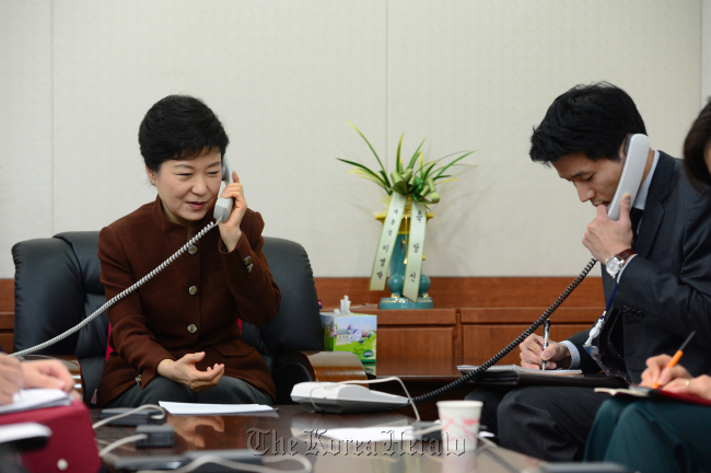 President-elect Park Geun-hye (left) talks to U.S. President Barack Obama in a telephone conversation at the Saenuri Party building in Yeouido, Seoul, Friday. Sitting on her left is an interpretor.   Park Hyun-koo/The Korea Herald