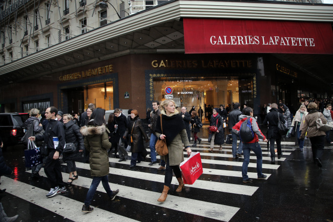 Shoppers walk past a Paris store decorated for Christmas on Dec. 20.   AP-Yonhap News