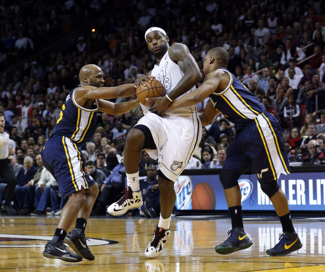 Miami Heat’s LeBron James (center) is fouled by Utah Jazz’s Randy Foye (right) and Jamaal Tinsley defends during the second half of an NBA basketball game in Miami on Saturday.   AP-Yonhap News