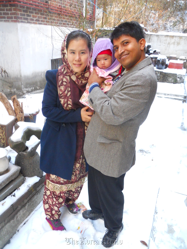 Yun Sue-kyung (left), baby Zia and Sheikh Imtiaz Ali pose for a photo outside their home in Dokbawi, northern Seoul.   Shalini Singh