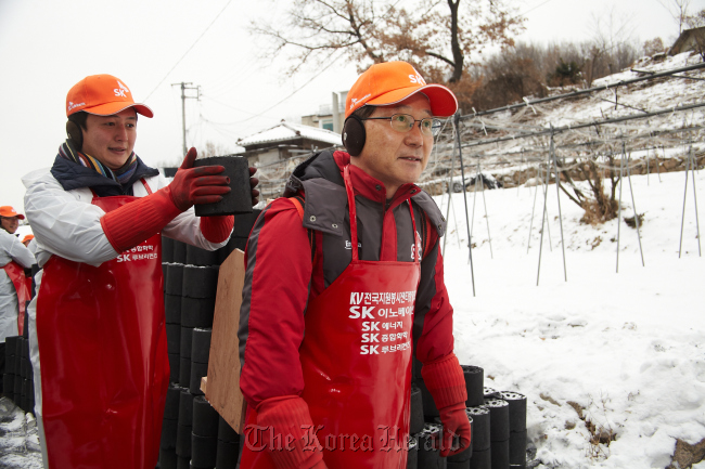 SK Innovation CEO Koo Ja-young (right) delivers coal briquettes with employees to low-income families living in Buam-dong in central Seoul early this month.   SK Innovation