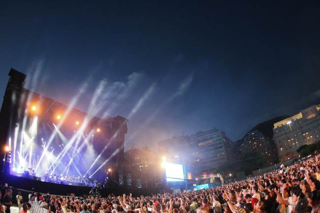 People attend a free Christmas concert as Brazilian musician Gilberto Gil performs on stage at Copacabana beach on Tuesday in Rio de Janeiro, Brazil.    AFP-Yonhap News