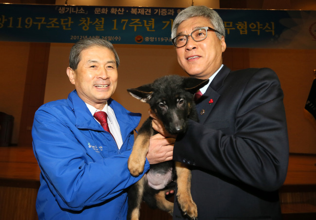 Hwang Woo-suk (left), chief technology officer of Sooam Biotech Research Foundation, poses with Lee Ki-hwan, administrator of National Emergency Management Agency, after donating two cloned German shepherds on Wednesday.   Yonhap News