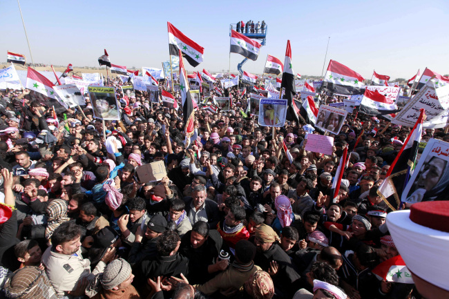 Protesters chant slogans against Iraq’s Shiite-led government as they wave national flags during a demonstration in Ramadi, 115 kilometers west of Baghdad, Wednesday.   AP-Yonhap News
