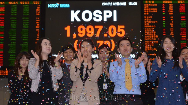 Korea Exchange employees celebrate the last trading day of 2012 at its Seoul office on Friday.   Lee Sang-sub/The Korea Herald